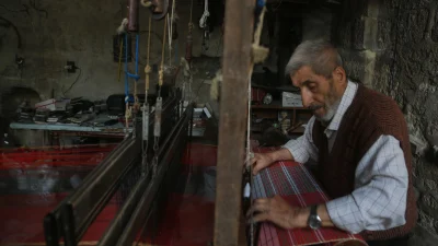 Halep’in son el dokuma ustalarından 80 yaşındaki Muhammed Ezrak, yarım