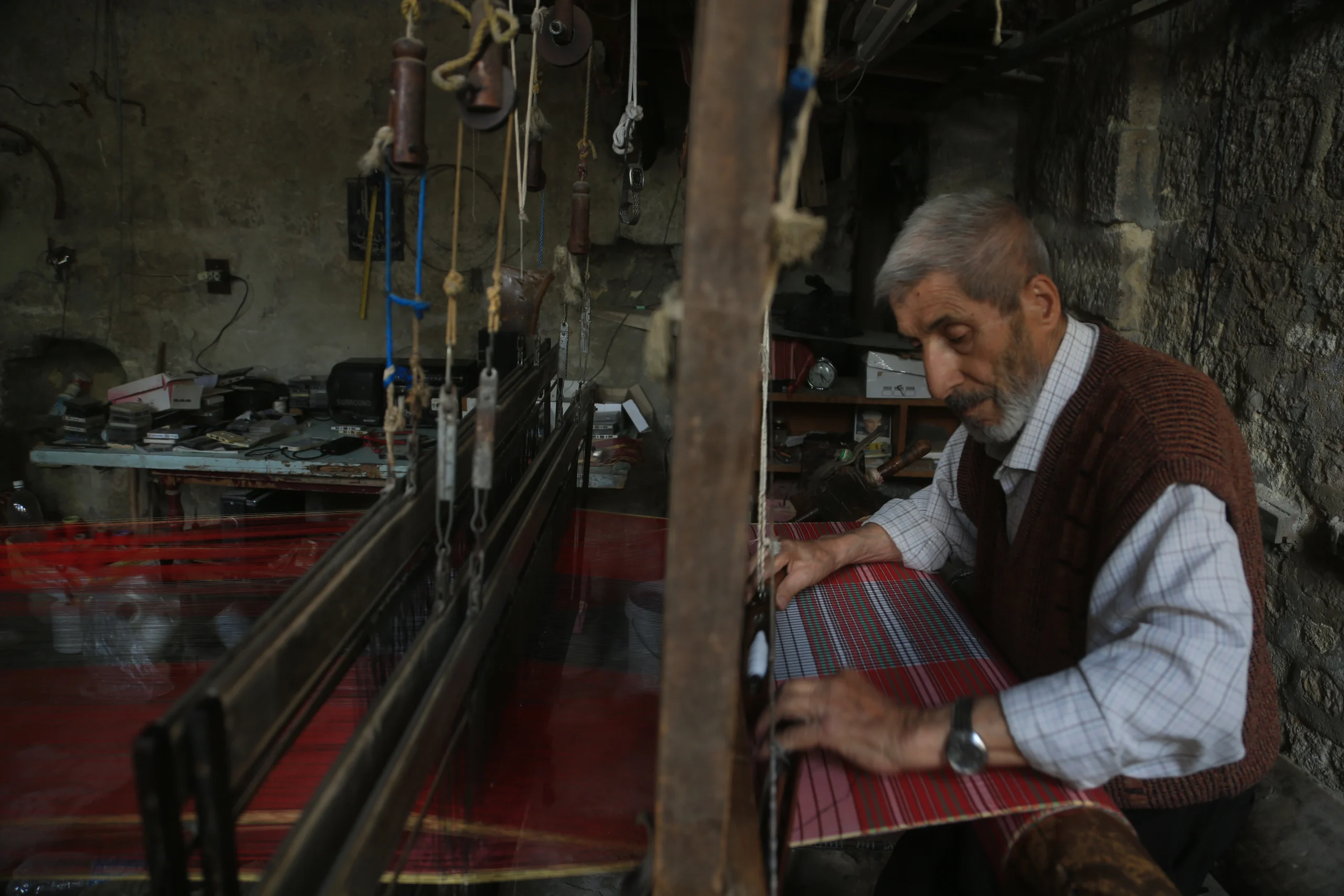 Halep’in son el dokuma ustalarından 80 yaşındaki Muhammed Ezrak, yarım